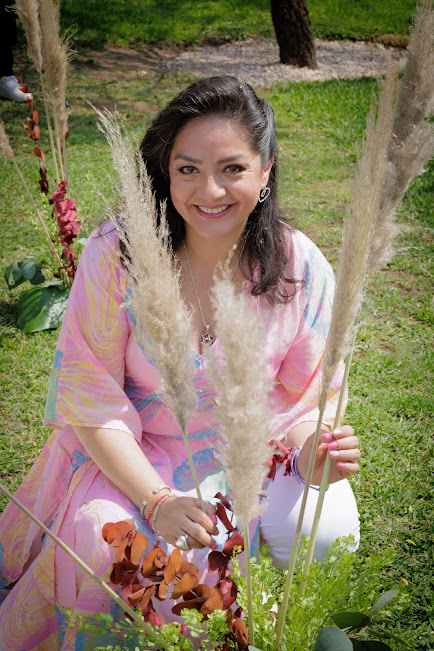 Ilia García sonriendo entre flores y naturaleza