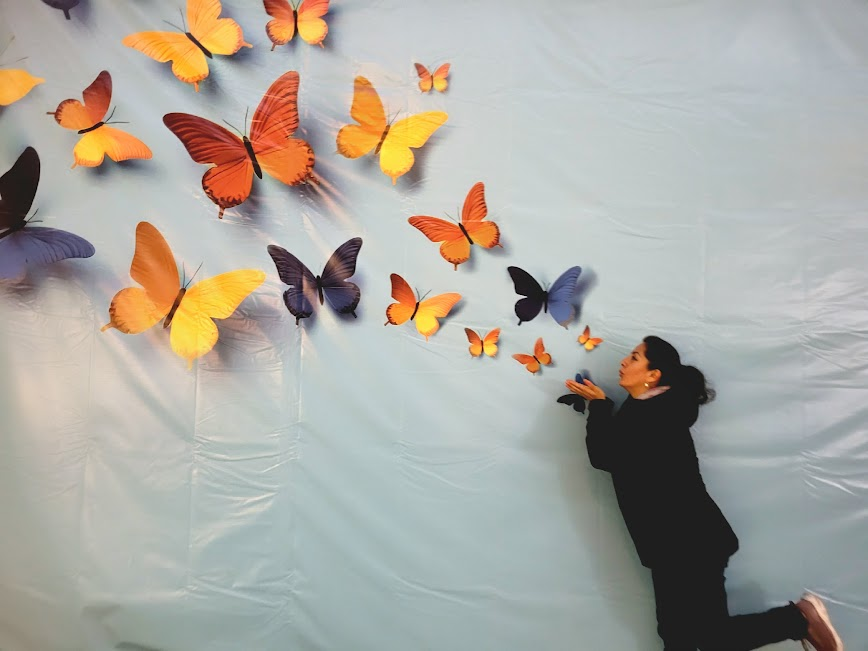 Ilia García soplando mariposas de colores